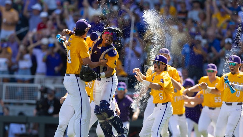 LSU pitcher Chase Shores, left, jumps into the arms of catcher Luis Hernandez, second left, as...
