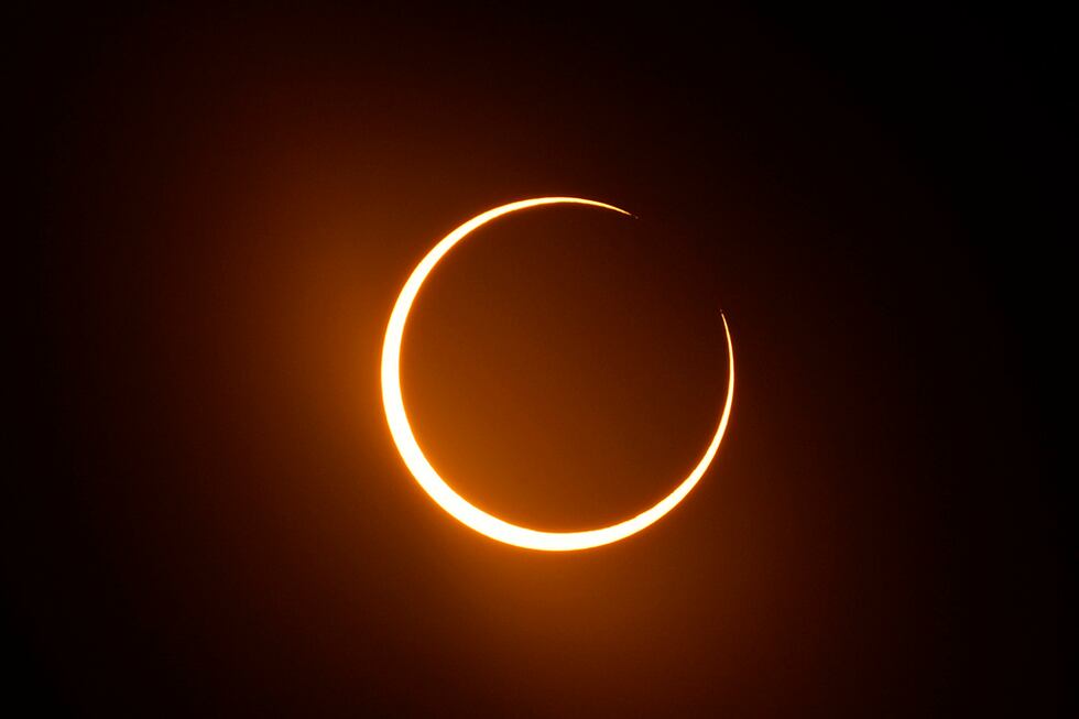 File - The moon moves in front of the sun during an annular solar eclipse, or ring of fire,...