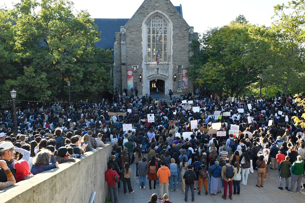 Demonstrators listen to a speaker during a protest against Cornell University's handling of...