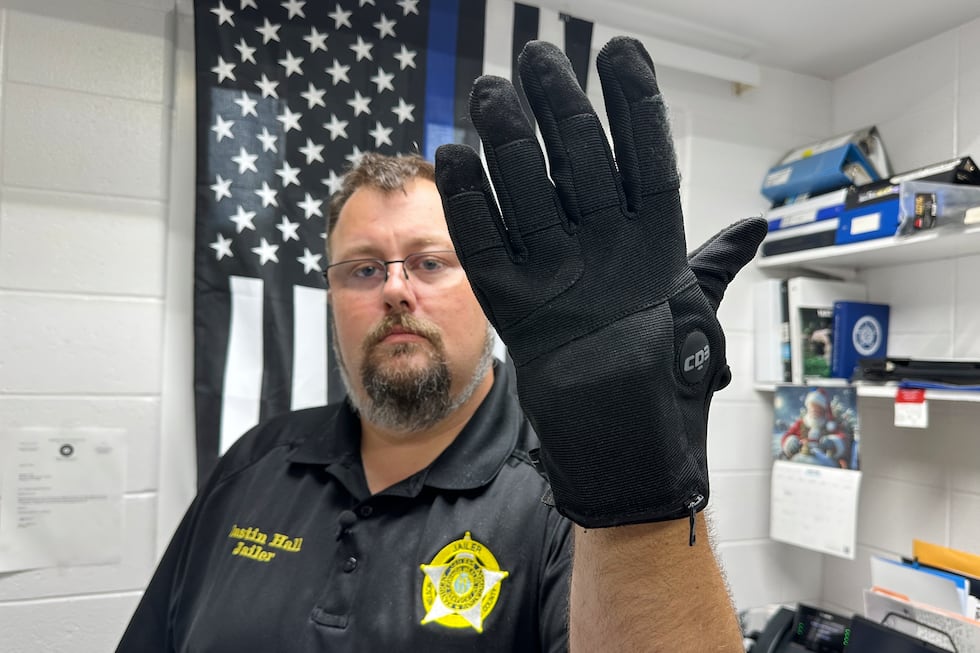 FILE - Nelson County, Ky., jailer Justin Hall shows an electric shock glove that is used at...