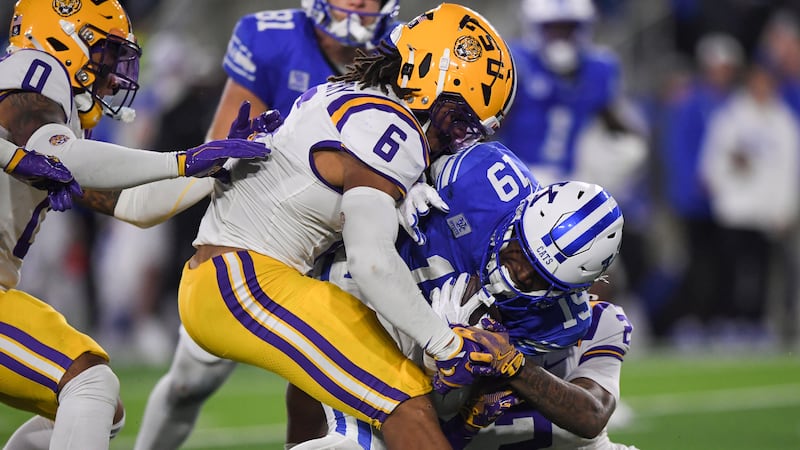 Kentucky wide receiver Kenny Darby (19) is tackled by LSU safety Ty Benefield (2) and...