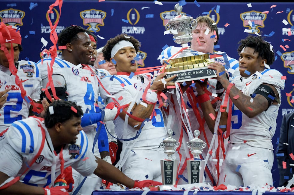 Mississippi quarterback Trinidad Chambliss, center, offensive lineman Patrick Kutas (75) and...
